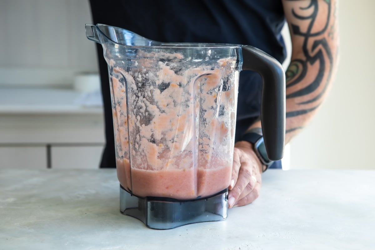Pink liquid for making Spanish rice in a blender pitcher.