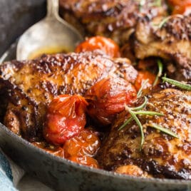 Balsamic chicken and tomatoes in a black dish.