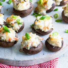 Crab stuffed mushrooms on a wooden platter.