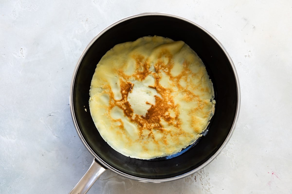 Cooking crepes in a pan.