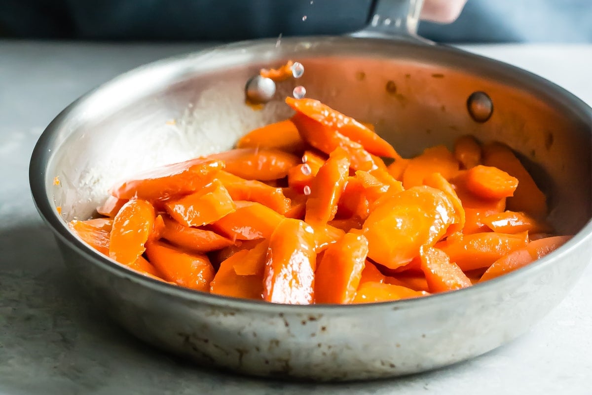Glazed carrots in a silver skillet.