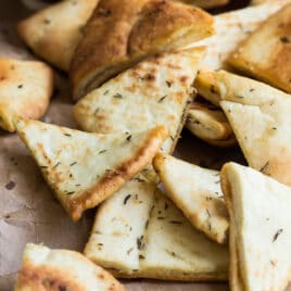 Pita chips on a piece of brown parchment paper.