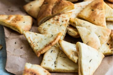 Pita chips on a piece of brown parchment paper.