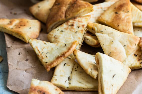 Pita chips on a piece of brown parchment paper.