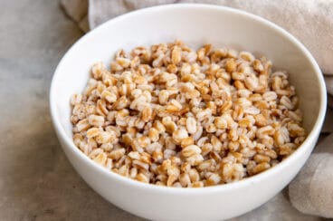 A white bowl with cooked farro in it.