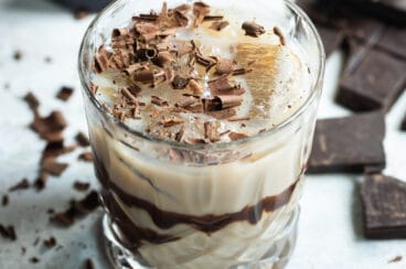 A mudslide cocktail with chocolate in the background.