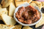 Roasted eggplant dip on a plate with triangles of bread.