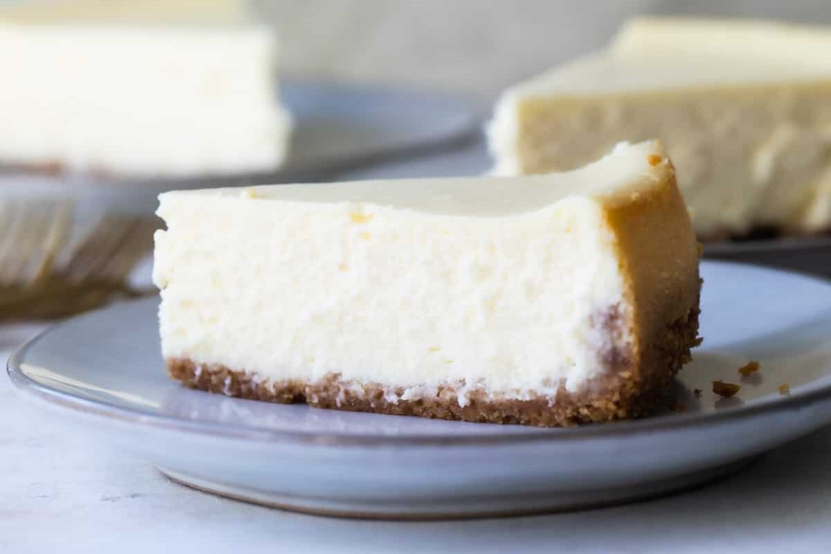 Slices of vanilla cheesecake on white plates.