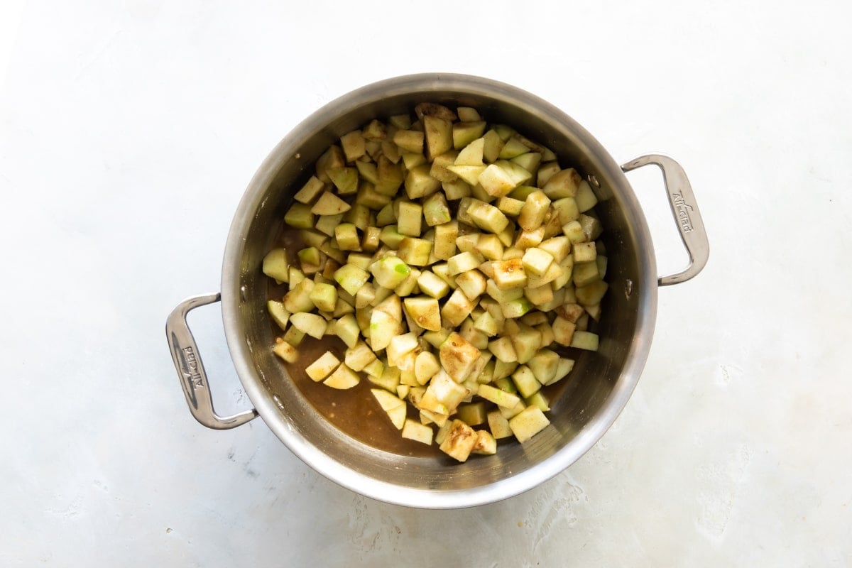Ingredients for apple pie filling in a silver pot.