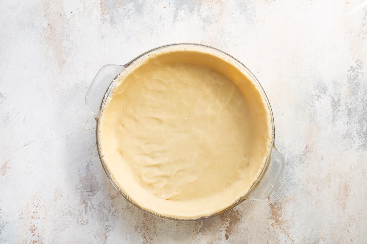 An unbaked pie crust in a pie pan.