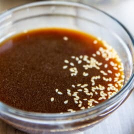 A bowl of Asian Salad Dressing sitting in front of a bowl of Chinese Chicken Salad.