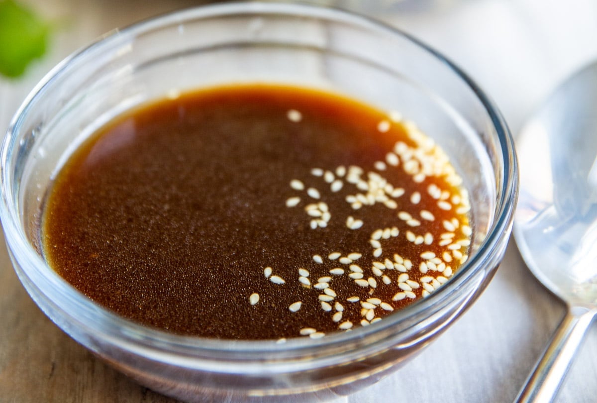 A bowl of Asian Salad Dressing sitting in front of a bowl of Chinese Chicken Salad.