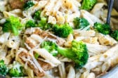 Cajun chicken alfredo with broccoli in a silver skillet.
