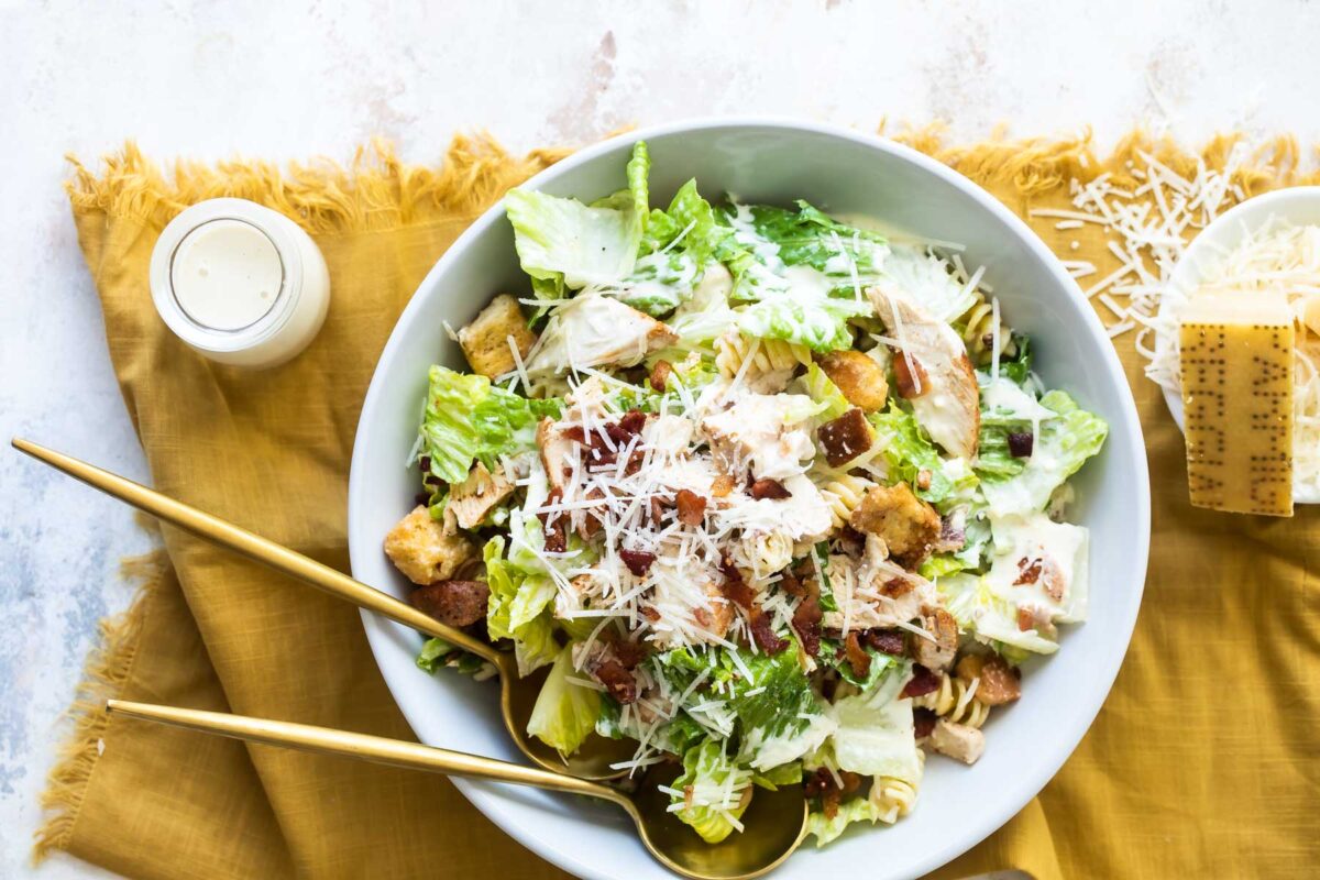 Chicken Caesar pasta salad in a white bowl.