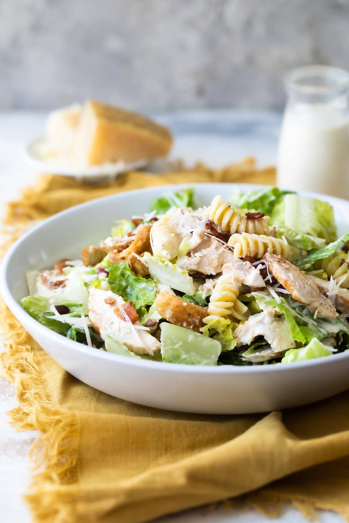 Chicken Caesar pasta salad in a white bowl.