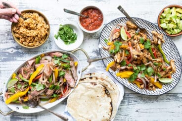 Chicken and steak fajitas on two serving platters.