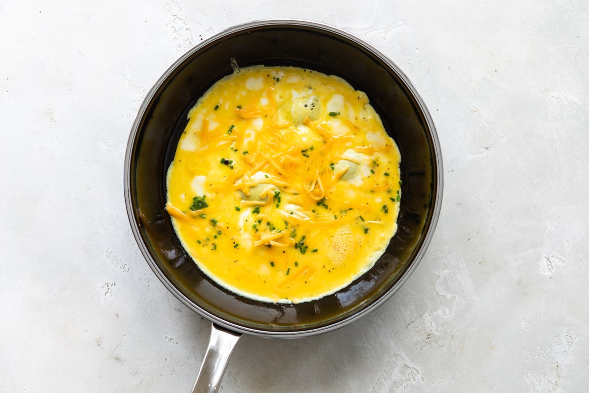 An egg burrito being cooked in a frying pan.