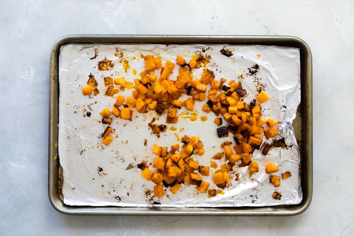 Butternut squash on a baking sheet after being roasted.