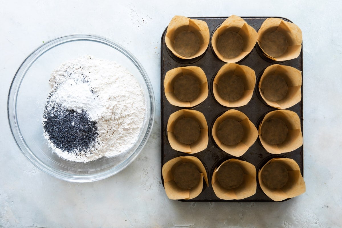 Muffin cups and dry ingredients for Lemon Poppy Seed Muffins.