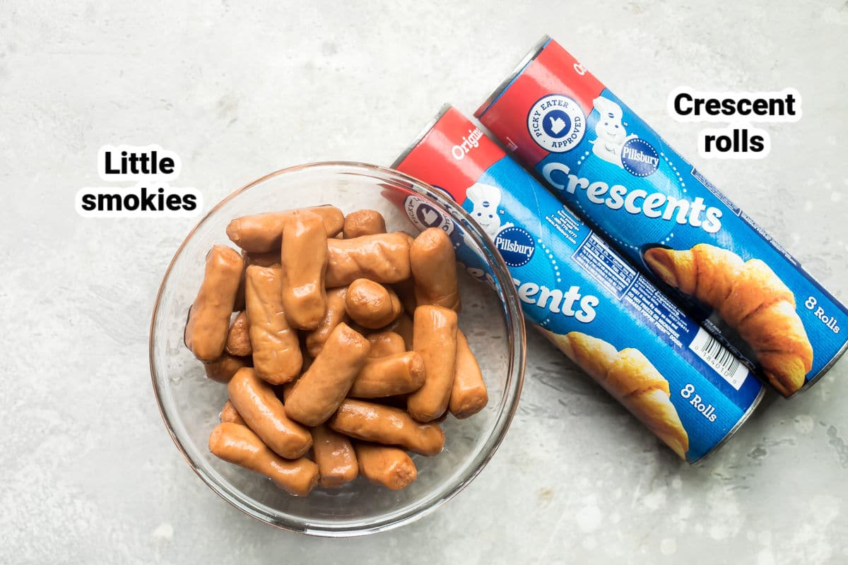 A bowl of cocktail wieners and packages of crescent roll dough.