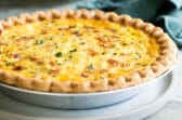 A quiche Lorraine in a silver pie pan.