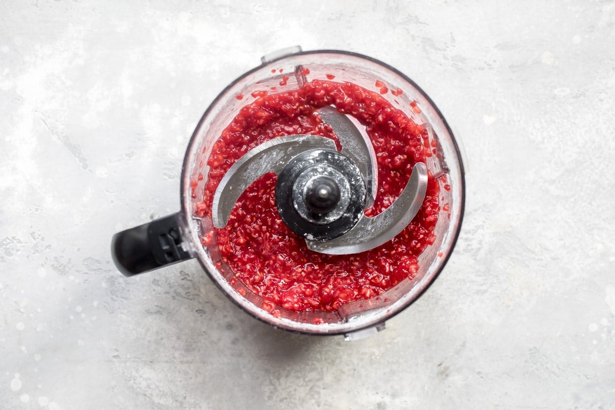 Pureed raspberries in a food processor.