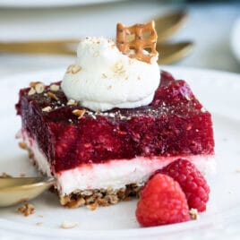 A slice of raspberry pretzel jello salad on a white plate.