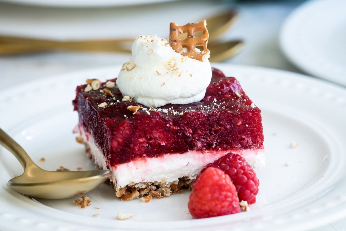A slice of raspberry pretzel jello salad on a white plate.