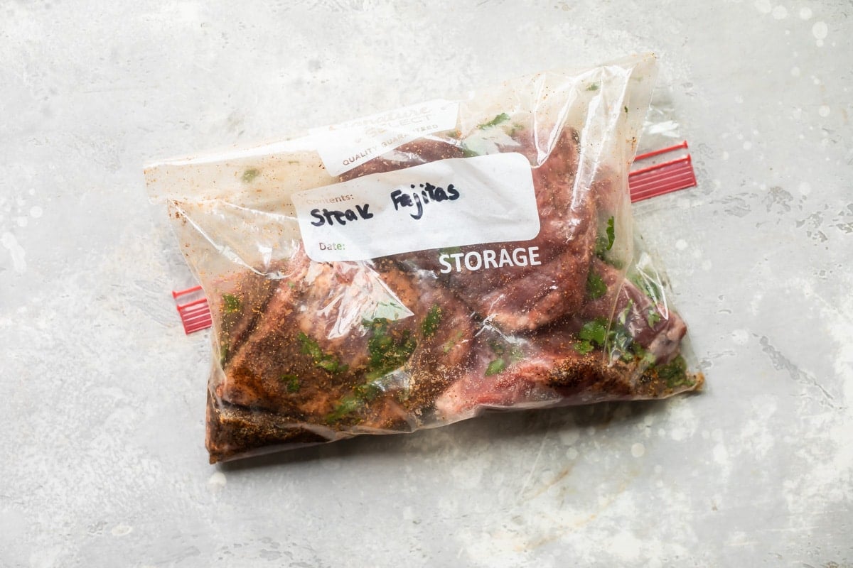 Steak being marinated in a Ziploc bag.