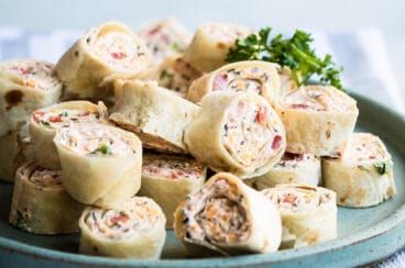 Taco tortilla roll ups on a blue platter.