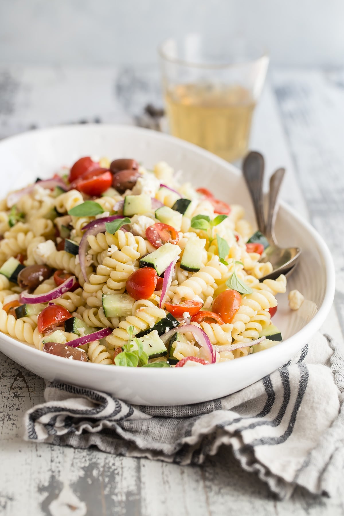 Greek pasta salad in a white bowl.