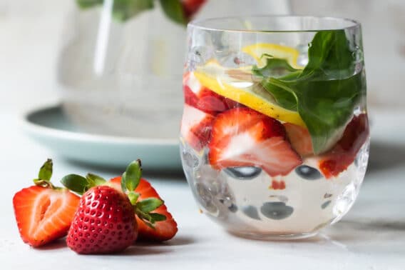 Glasses of water infused with fruit, vegetables, and fresh herbs.