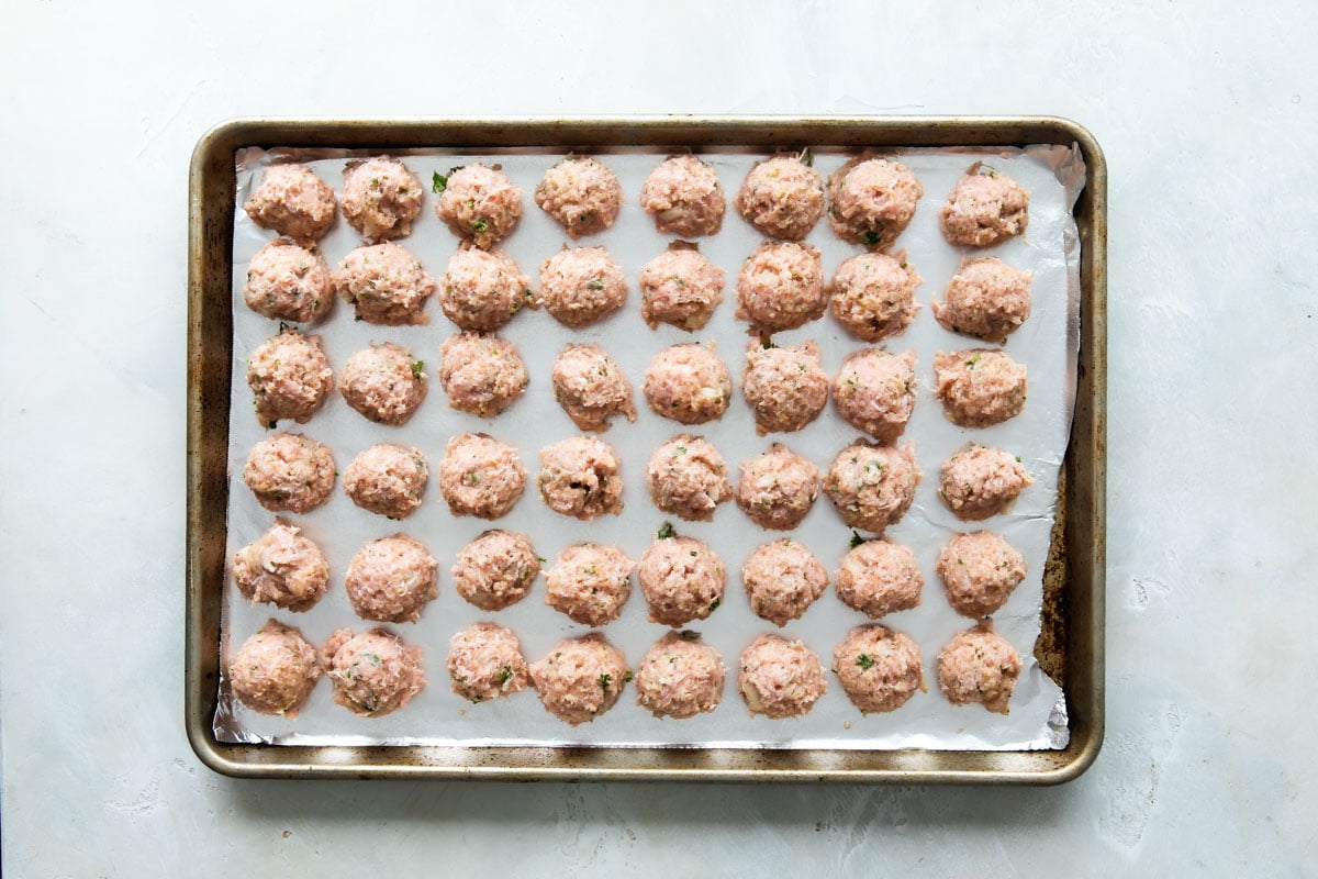 Meatballs on an aluminum foiled lined baking sheet.