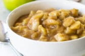 Apple pie filling in a white bowl.