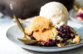 A plate of blackberry cobbler with vanilla ice cream.