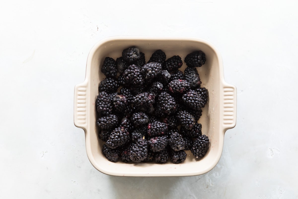 A baking dish with blackberries for cobbler.