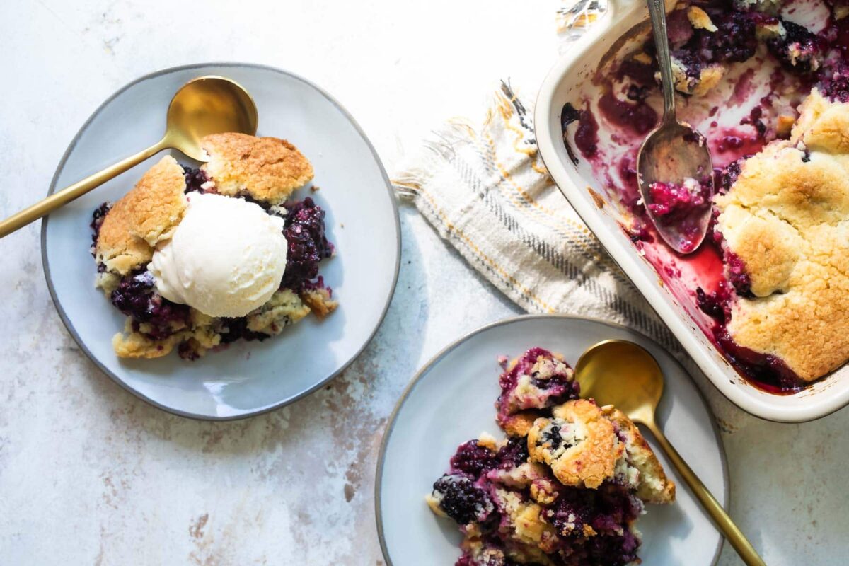 A plate of blackberry cobbler with vanilla ice cream.