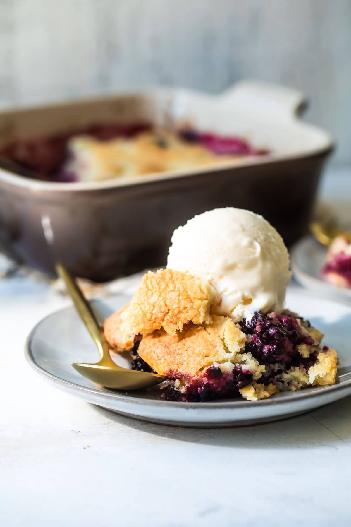 A plate of blackberry cobbler with vanilla ice cream.