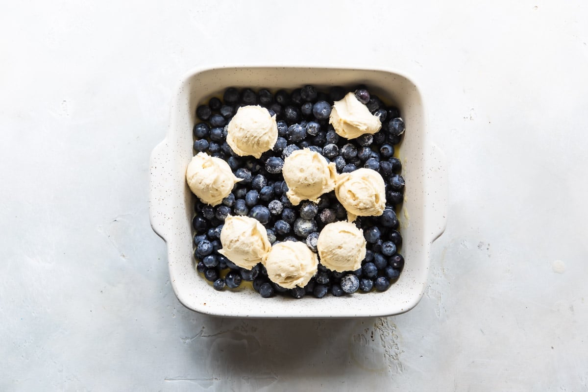 A baking dish of unbaked blueberry cobbler.