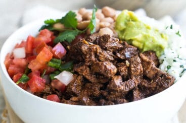 A bowl of Chipotle steak, pinto beans, cilantro-lime rice, and pico de gallo.