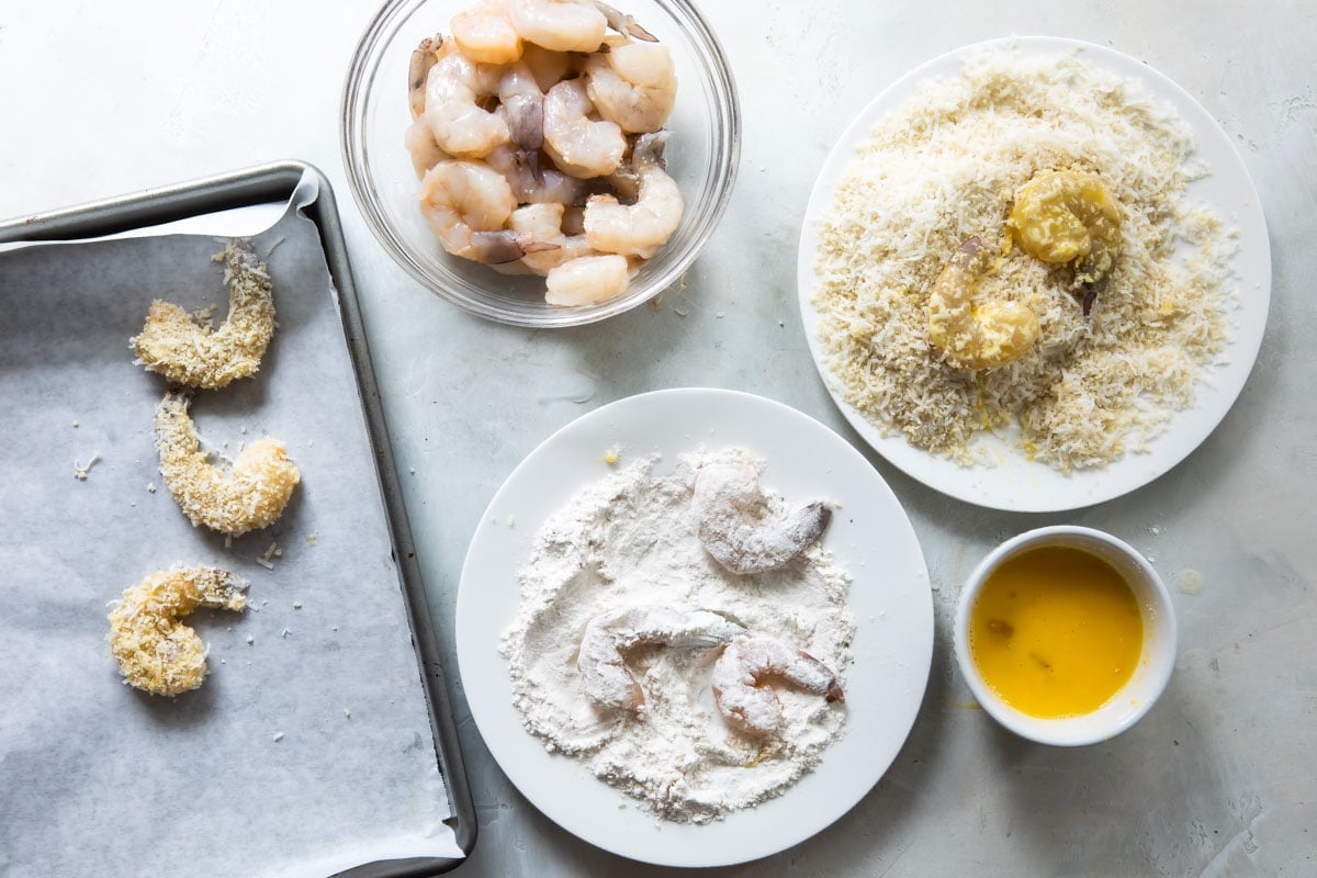 Coconut shrimp being breaded.