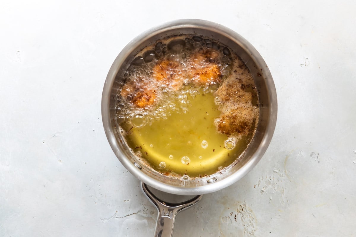 Coconut shrimp frying in oil.