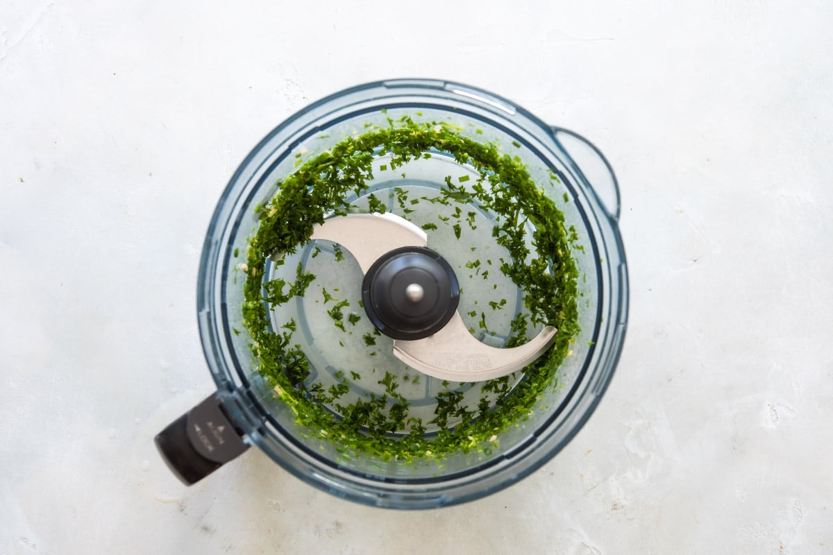 Green herbs minced in a food processor.