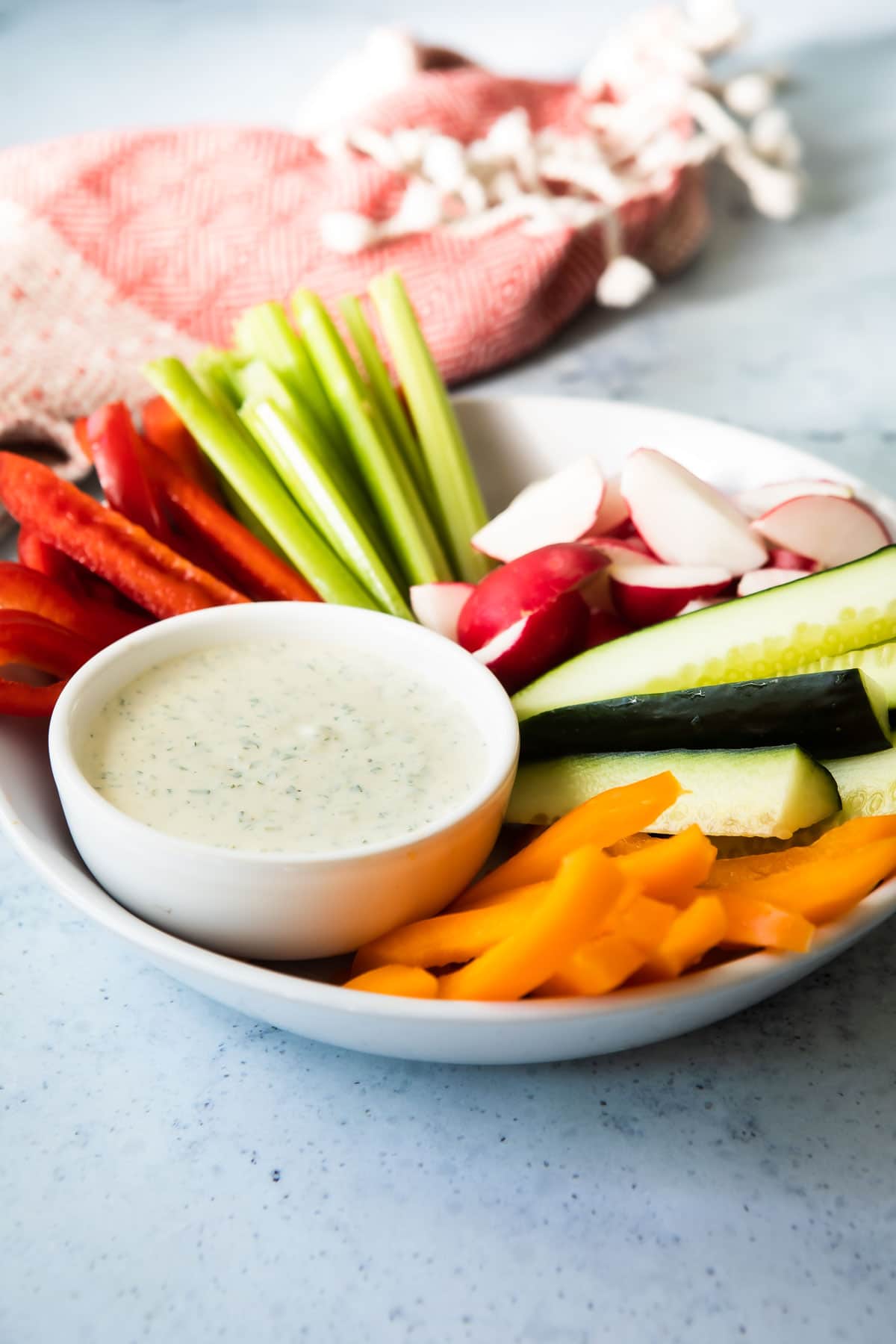 A veggie platter with a dish of green Goddess dressing.