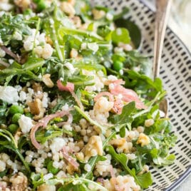Israeli Couscous salad on a white and black platter.