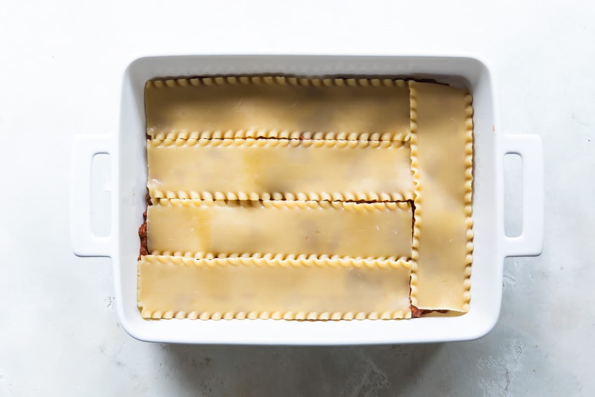Sauce and noodles layered to make lasagna.