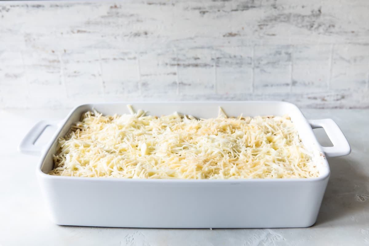 3 layers of unbaked lasagna in a baking dish.