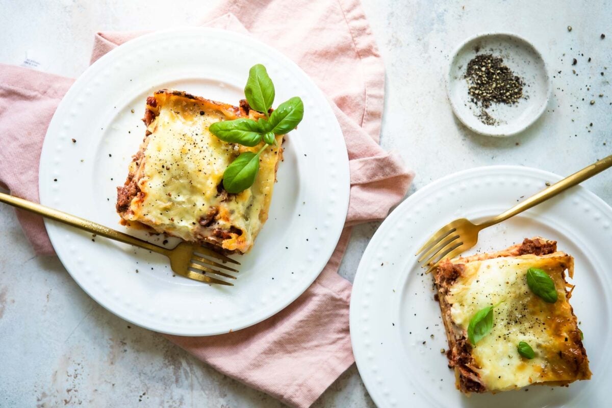 A piece of lasagna on a white plate.