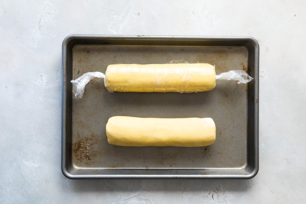 Logs of lemon cookie dough on a baking sheet.