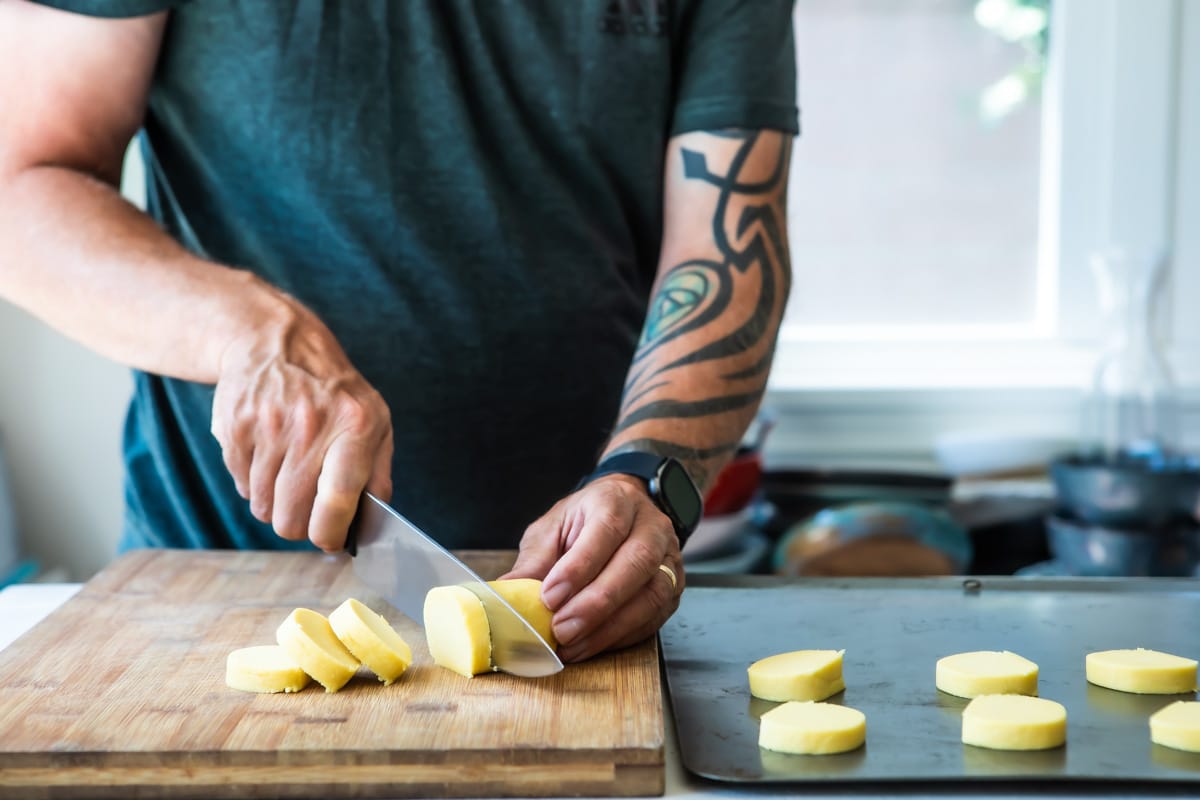 Lemon cookie dough being cut into circles.